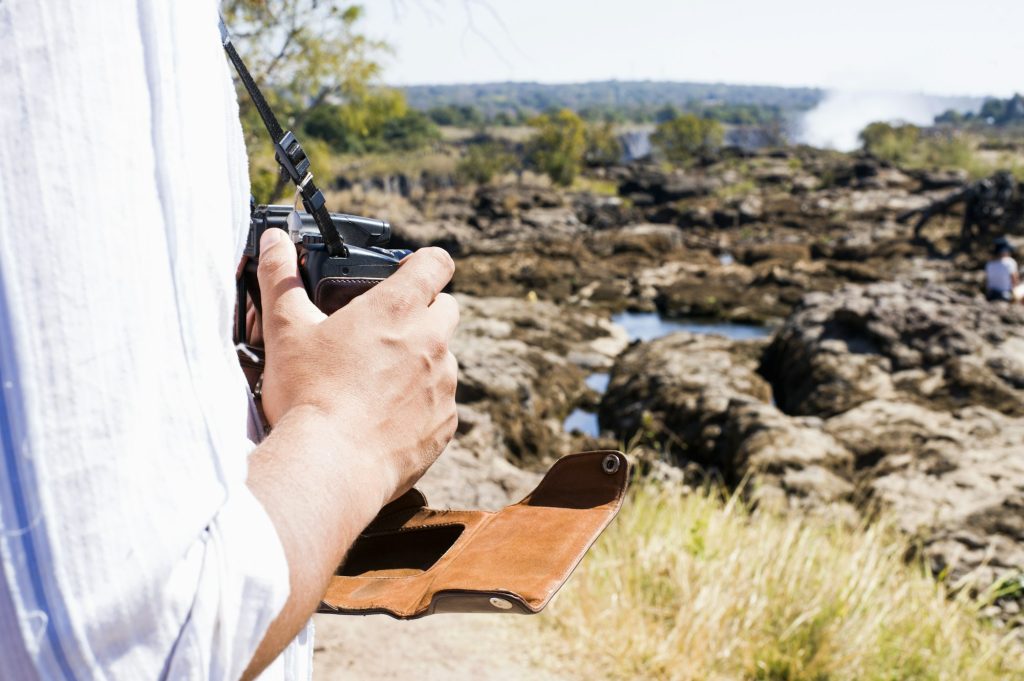 Cropped shot of man using camera near Victoria Falls, Zambia